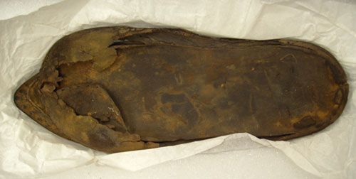 One of many leather shoes retrieved from Trinity Harbour.  The stiching holes are still visible in the upper portion of the shoe - Une chaussure en cuir d'un naufrage dans le port de trinit. Les trous stiching sont encore vidents dans la partie suprieure de la chaussure.